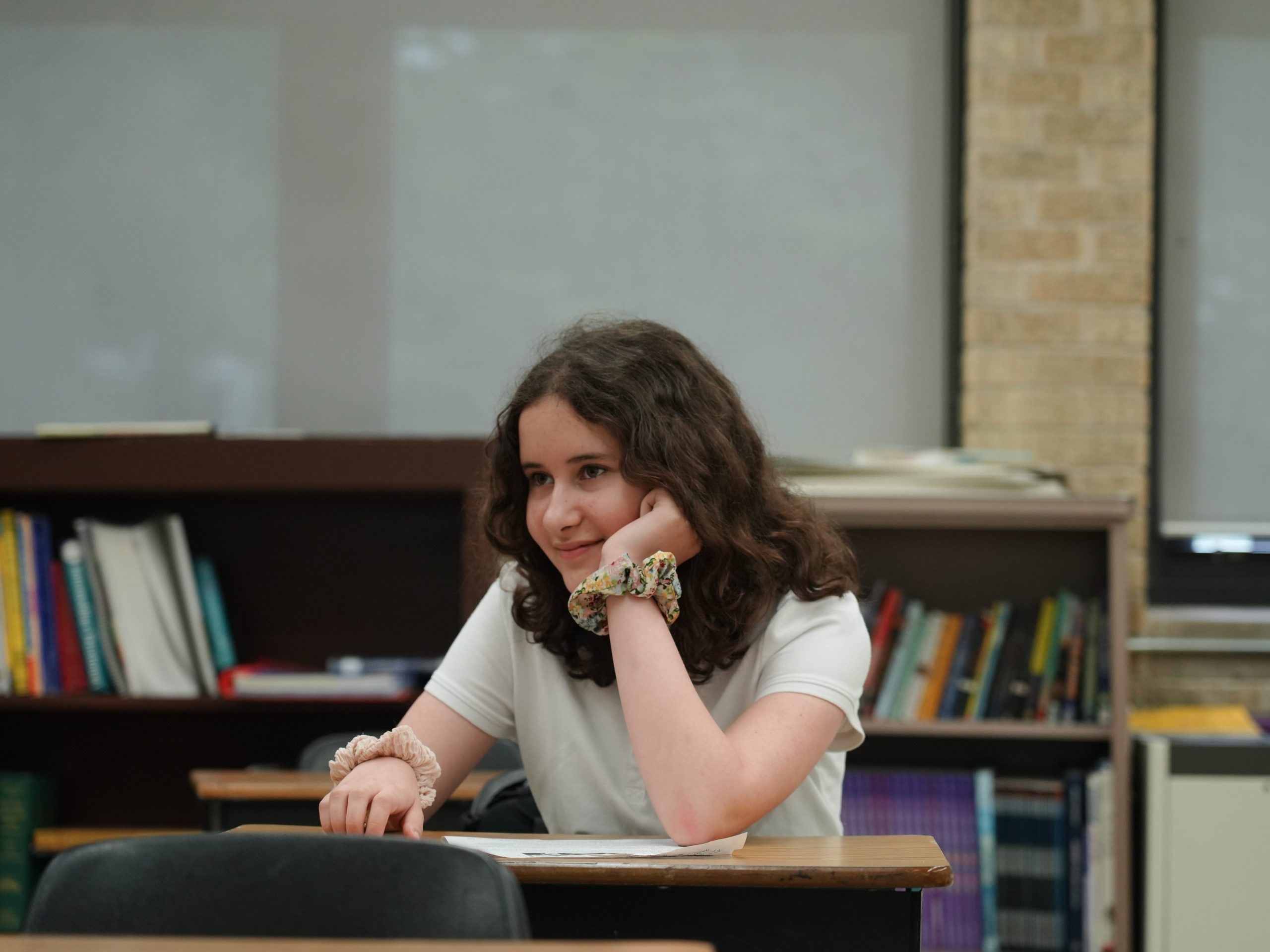 6th grade student sitting at desk listening to teacher.