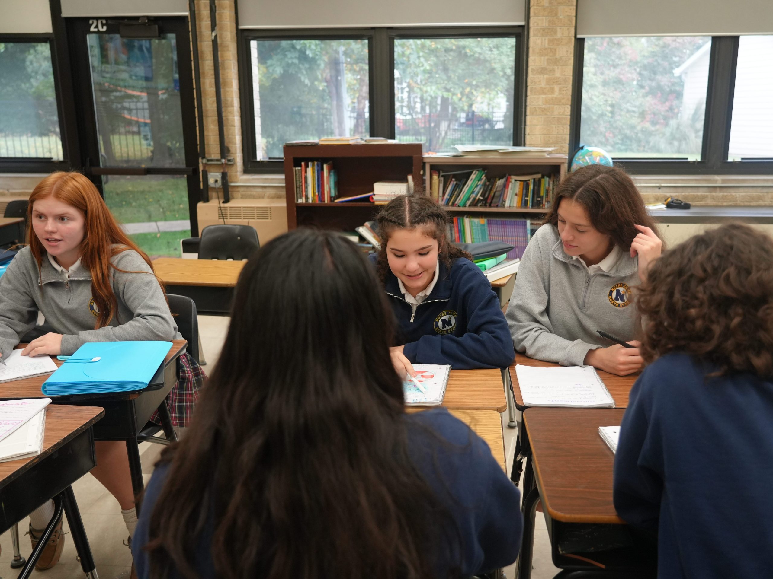 8th grade students working in small groups having discussions.