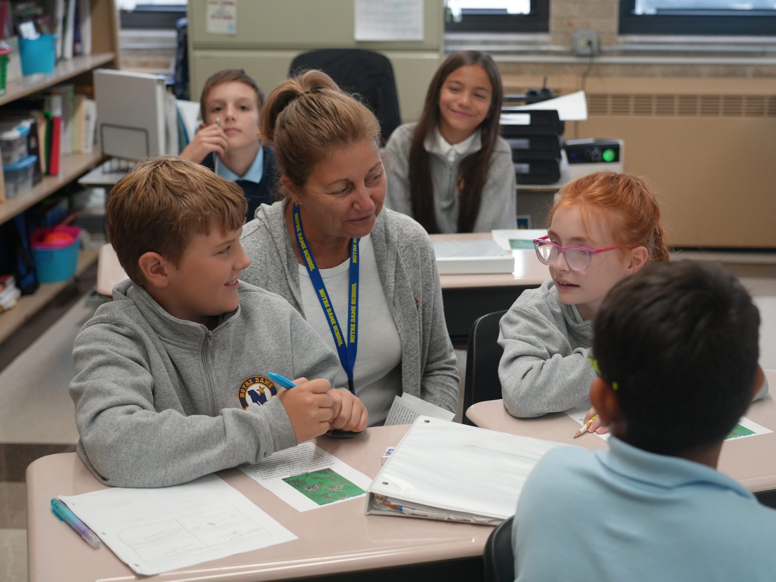 Teacher helping two 5th grade students in science class.