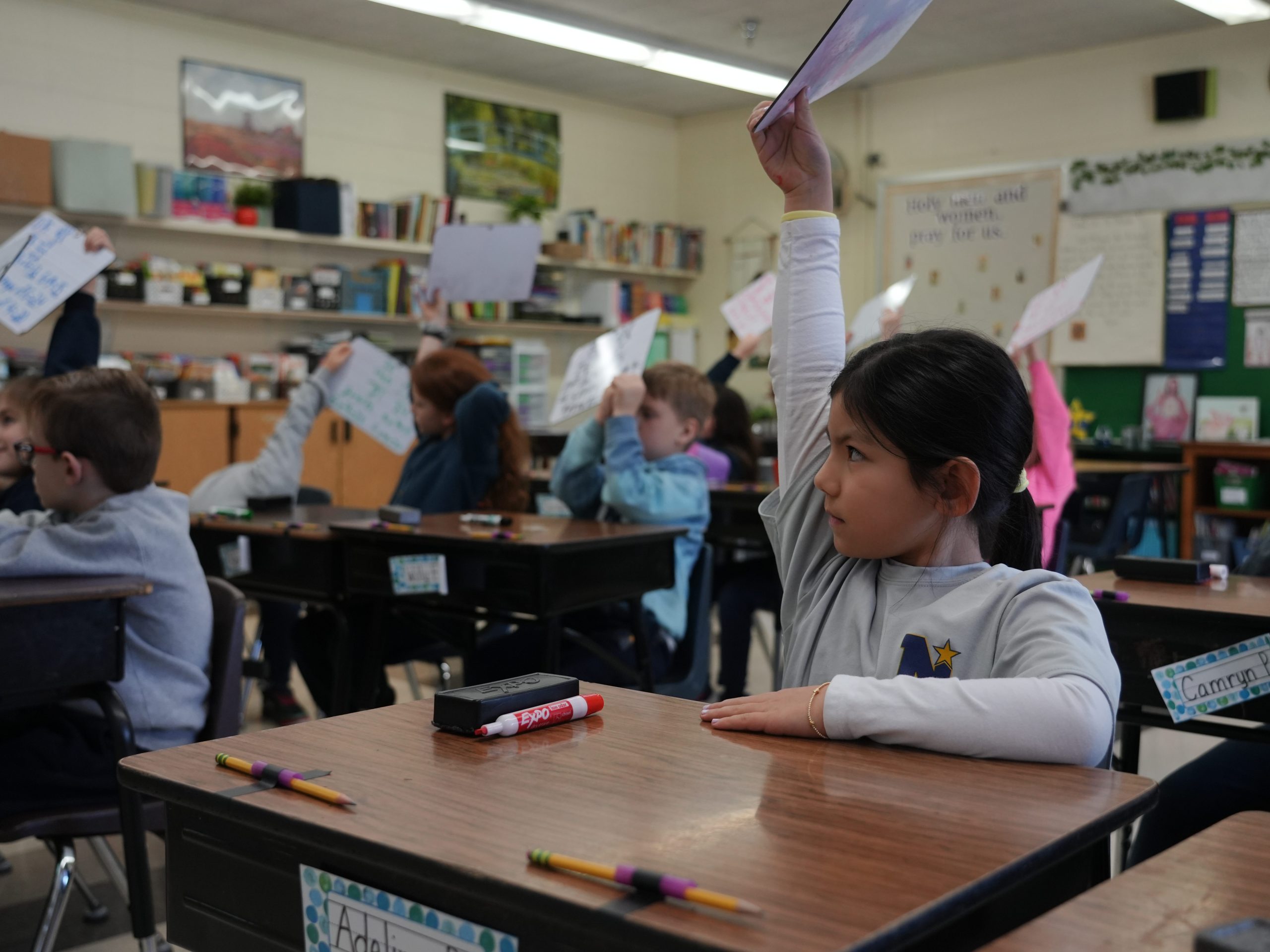 2nd grade students showing their answers on their whiteboards.